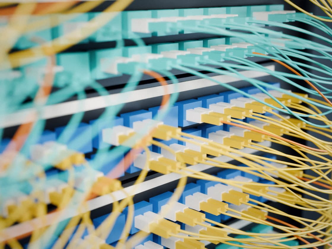 Yellow and aqua fibre patch cords plugged into a patch panel